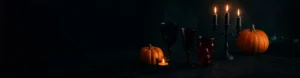 Dark-themed Halloween table setting with pumpkins, candles, and spooky glassware