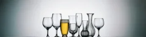 A collection of various glassware items, including wine glasses, beer mugs with golden beer, tumblers, and decorative vases, arranged neatly against a light background. Ideal for buyers exploring options for international import and export.