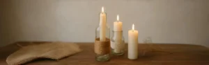DIY glass bottle candle holders made from recycled materials, displayed on a rustic wooden surface under natural light, with soft candle glow and handmade jute details.