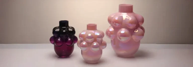 Three modern iridescent bubble glass vases in gradient pink and purple tones displayed under soft natural light.